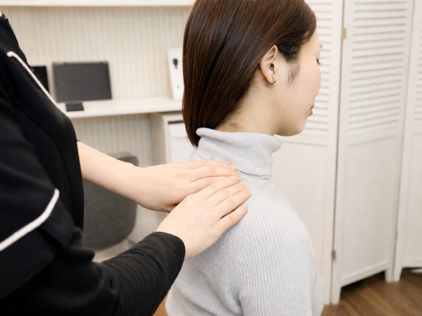 肩まわりに手を当てて施術している様子